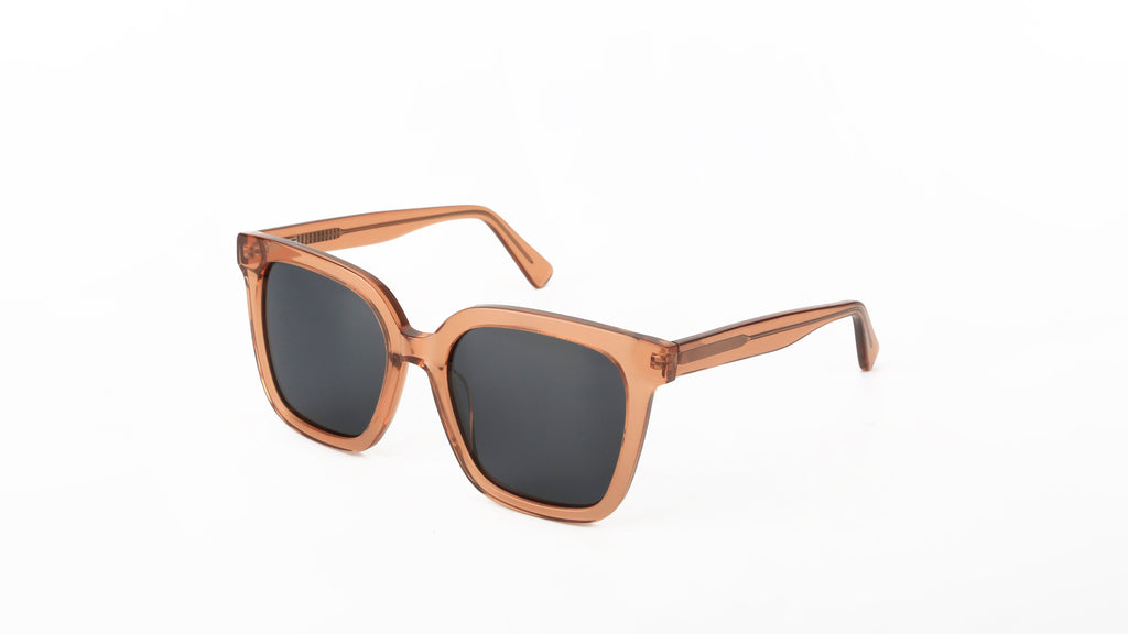 A pair of square-frame sunglasses with a translucent copper-toned acetate frame and dark gray lenses, shown on a plain white background.