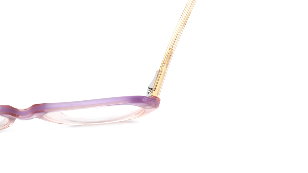 Close-up of a pair of eyeglasses showing a translucent lavender-purple acetate frame and gold metal temples on a solid white background.